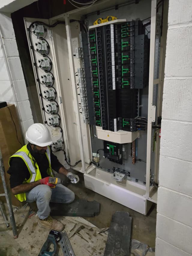 Electrician working on electrical wiring, ensuring safety and precision.